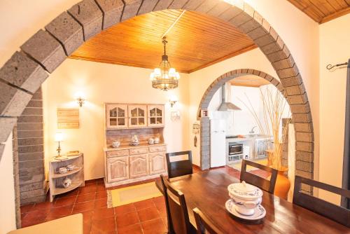 富尔纳斯CASA INTI / INTI HOUSE FURNAS的房屋内的厨房和用餐室,配有拱门