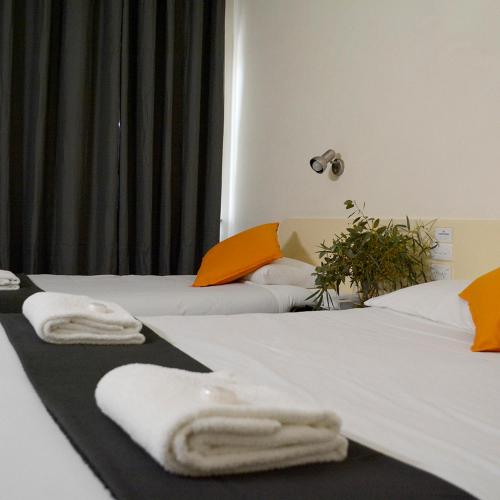TemoraShamrock Hotel Motel Temora的两间带毛巾的床(位于酒店客房内)