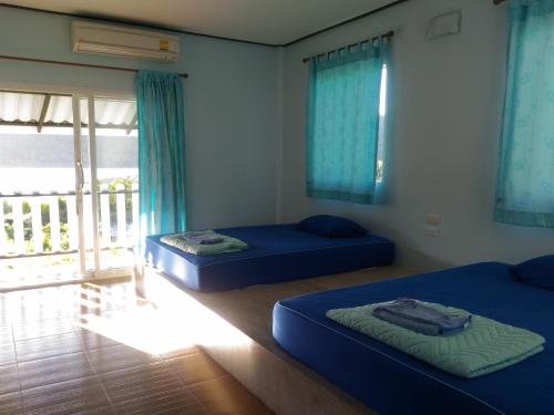 库德岛阁骨岛敖萨拉特景观旅馆的配有两张床铺的蓝色床单和窗户