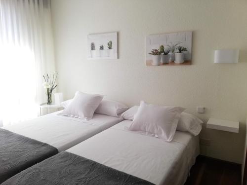 巴拉卡Apartamento Tellería con parking gratis的卧室内的两张床和白色枕头