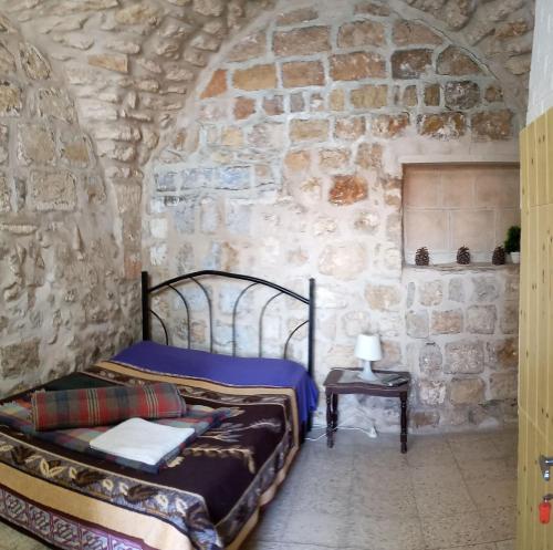 耶路撒冷Jaffa Gate Hostel的一间卧室设有两张床和石墙