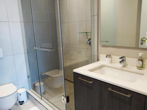 比勒陀利亚Menlyn Apartment的一间带水槽和玻璃淋浴的浴室