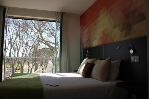 巴尔基尼亚新镇Barquinha River House的一间卧室设有一张床和一个大窗户