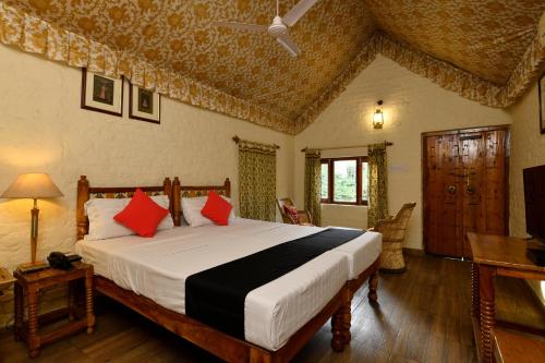 珀勒德布尔Hotel Sunbird的一间卧室配有一张带红色枕头的大床