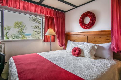 镭温泉Gables Motel的一间卧室配有一张大床,上面有花圈
