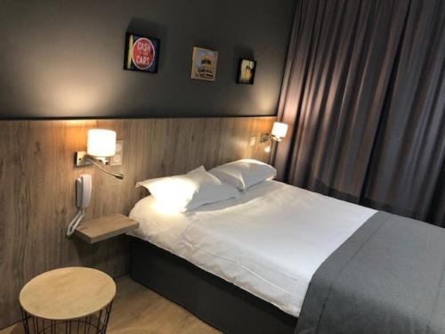 图卢兹维克多雨果酒店的一间卧室配有一张床、一张桌子和一部电话
