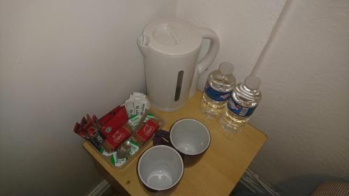 布莱克浦MyRoomz Orchid Hotel的一张桌子,上面放着垃圾桶和两个杯子