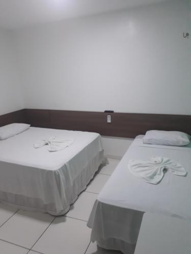 特雷西纳Pousada Pampa Gaúcho的两张睡床彼此相邻,位于一个房间里