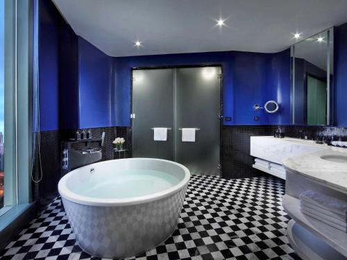 曼谷曼谷 SO/ 酒店的一间带大浴缸和蓝色墙壁的浴室