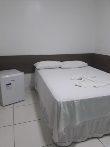 特雷西纳Pousada Pampa Gaúcho的一张带白色床单和枕头的床