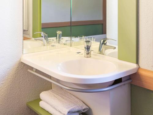 圣格拉蒂安圣格拉蒂 - 昂吉安莱班安宜必思经济酒店 的浴室设有白色水槽和镜子
