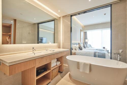 余姚余姚伯瑞特酒店的一间带大镜子和浴缸的浴室