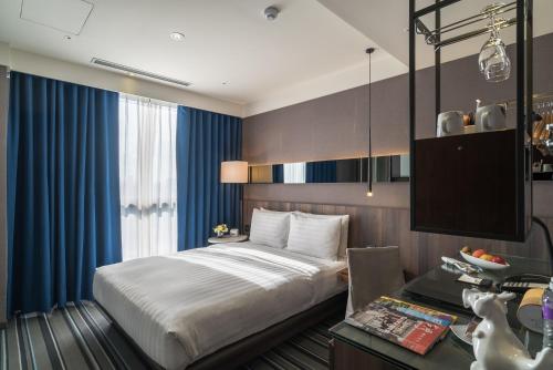 台北永安栈的一间卧室配有一张床、一张书桌和一台电视