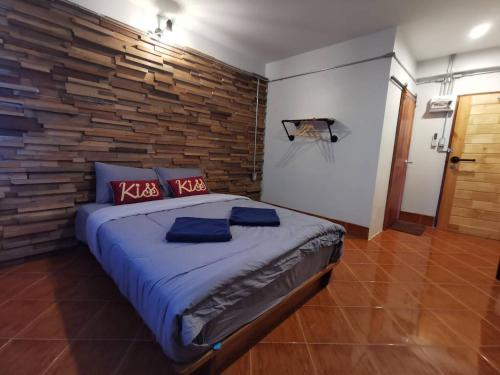 沙敦Pakarang Resort的一间卧室设有一张带木墙的大床