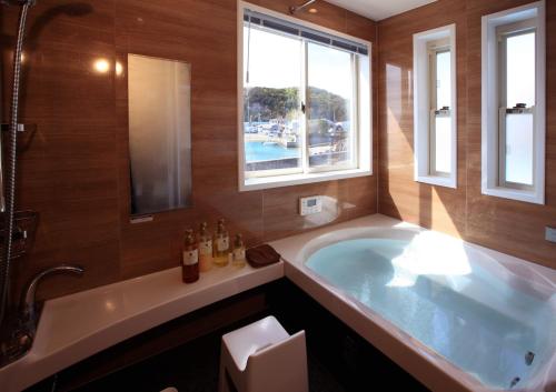 白滨Daikyo Engtsuto Villa的带浴缸和窗户的大浴室
