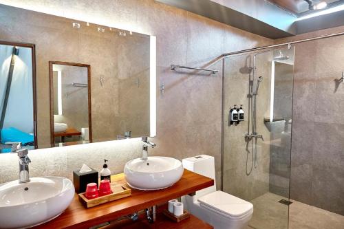 拉古洼安梦民丹岛度假村的一间带两个盥洗盆、淋浴和卫生间的浴室