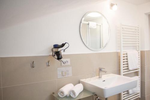 思科纳Schenna Garni Eden Bed & Breakfast的一间带水槽和镜子的浴室