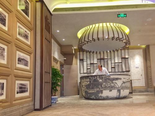 上海锦江都城经典上海南京饭店的站在大厅柜台上的人