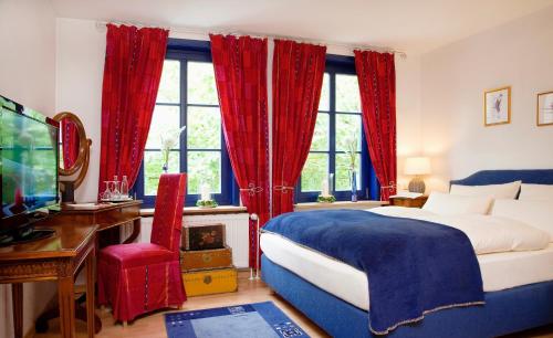 黑明根Landhaus Artischocke的一间卧室配有一张带红色窗帘的床和电视。