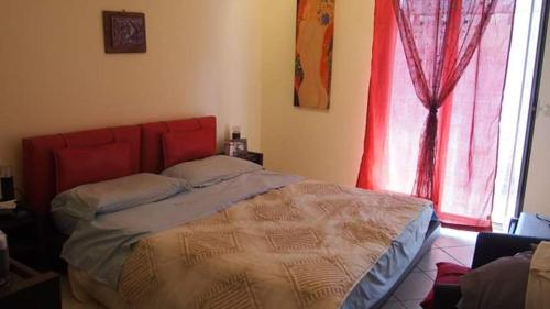 梅克内斯Youth Hostel Medina的一间卧室配有一张带红色床头板的床和窗户