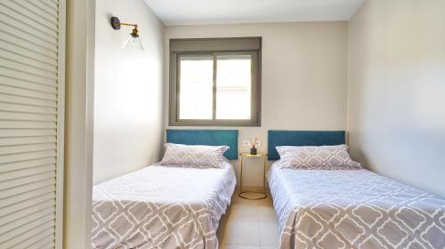 贝纳尔马德纳Sea View Penthouse, Pool, Privacy, Benalmadena的带窗户的客房内设有两张单人床。