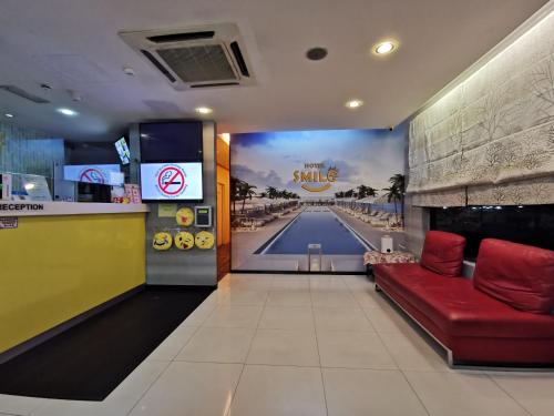 吉隆坡吉隆坡富都蕉赖微笑酒店的一间设有游泳池的餐厅,并在一间房间内配有一张红色沙发