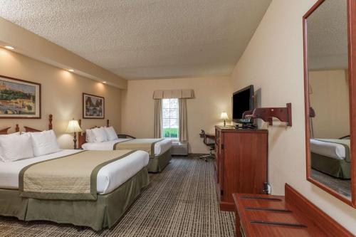 哥伦比亚Baymont by Wyndham Columbia Maury的酒店客房设有两张床和电视。