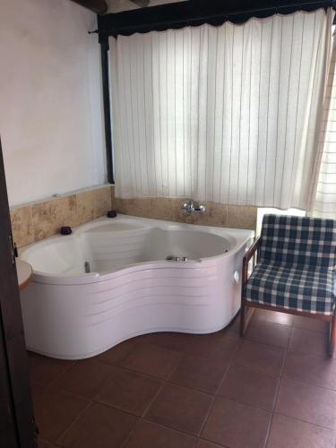 Potamitissa安贝里克斯传统农庄酒店的带浴缸的浴室和椅子