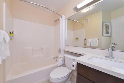 圆石城奥斯汀-朗德罗克烛木套房酒店的浴室配有卫生间、盥洗盆和浴缸。