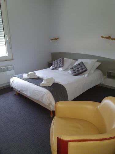 Salies-du-Salat都帕克酒店的一间卧室配有一张床和一张黄色椅子