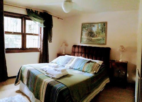 圣弗朗西斯科-迪保拉Nanda's House Pousada的一间卧室配有带毛巾的床