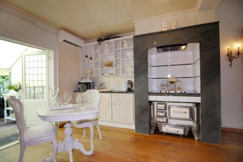 马斯特里赫特蒙雷威套房酒店的厨房配有桌子、冰箱和炉灶。
