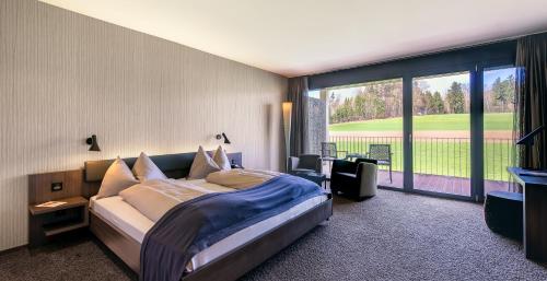 利普斯维尔高尔夫全景疗养酒店的一间卧室设有一张大床和一个大窗户