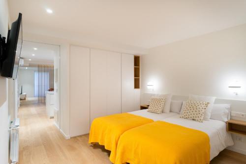 圣塞瓦斯蒂安Fermin Suite - Iberorent Apartments的一间卧室配有一张带黄色毯子的大床