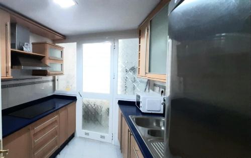 塞维利亚Apartamento Realengo Sevilla的厨房配有冰箱、水槽和窗户。