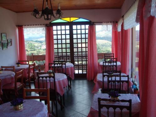 坎波斯杜若尔当Pousada Cachyto de Cielo的一间设有桌椅的餐厅,位于带窗户的房间内