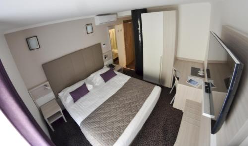 埃维昂莱班依云萨瓦酒店的一间小卧室,配有一张床和镜子