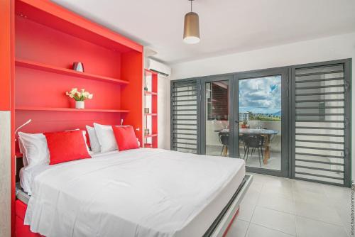 法兰西堡STUDIO EQUIPE A L ETANG Z ABRICOTS的红色卧室配有白色的床和一张桌子