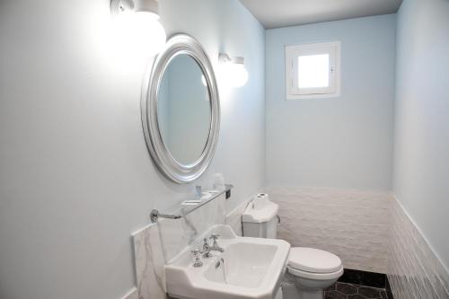 ViarmesAuberge la Renaissance的一间带水槽、卫生间和镜子的浴室
