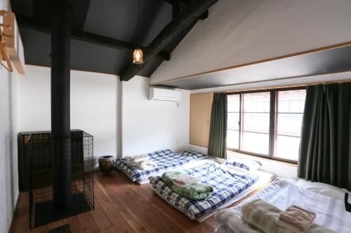 NagaokaGuesthouse Izame Ann的带大窗户的客房内的两张床