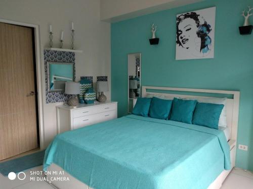 纳苏格布Lagoon view Family Suite in Pico De Loro Cove, Nasugbu的一间卧室配有一张带蓝色床单和镜子的床