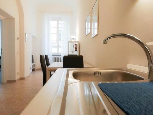 萨沃纳MistrangeloHome 5 - Appartamento in Pieno Centro的厨房配有水槽和桌椅