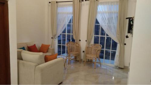 努沃勒埃利耶富豪玫瑰奢华度假公寓的带沙发、椅子和窗户的客厅