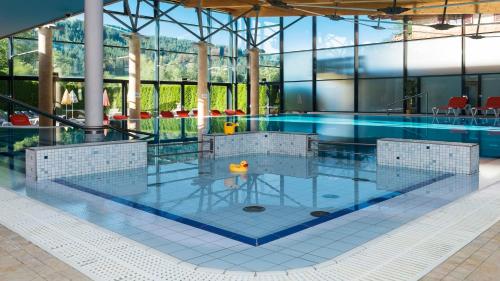 基茨比厄尔Bruggerhof - Camping, Restaurant, Hotel的一座带玻璃墙的建筑中的游泳池
