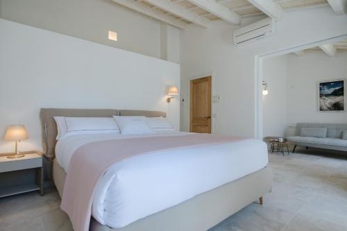 休达德亚Samarés的白色卧室设有一张大床和一张沙发