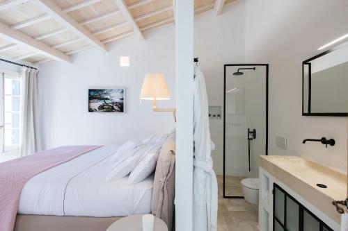 休达德亚Samarés的一间白色卧室,配有床和一间浴室