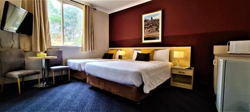 墨尔本布伦瑞克大厦酒店的酒店客房,配有床和电视