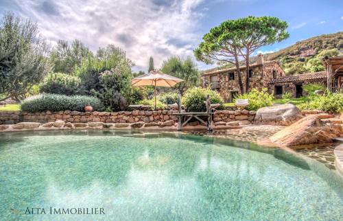 维琪奥港Villa Serenita Pallombaggia的院子里带遮阳伞的游泳池