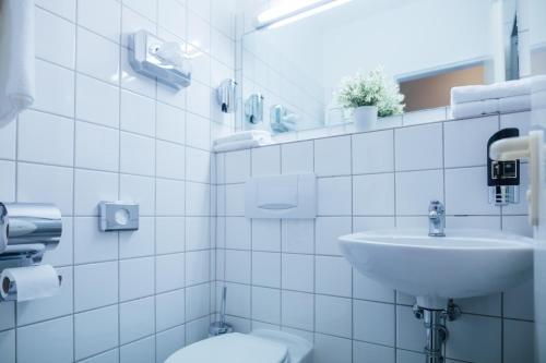 汉堡Hotel CULT Hamburg的白色的浴室设有水槽和卫生间。