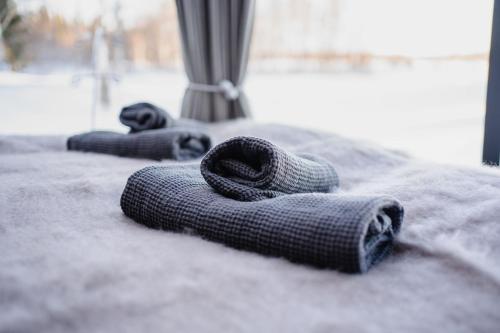 罗瓦涅米Ollero Eco Lodge (including a glass igloo)的几条毛巾坐在床上
